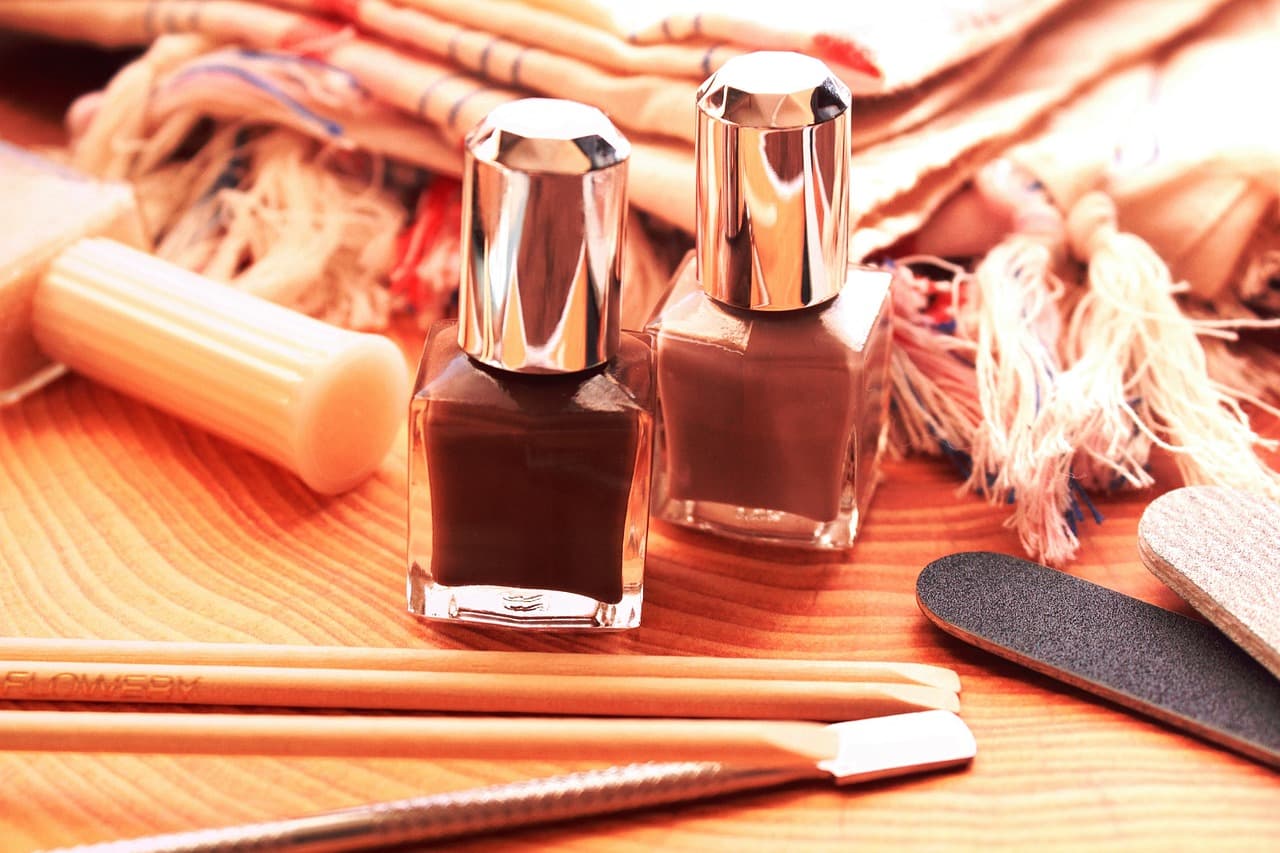Two bottles of nail polish with a nail file and buffer